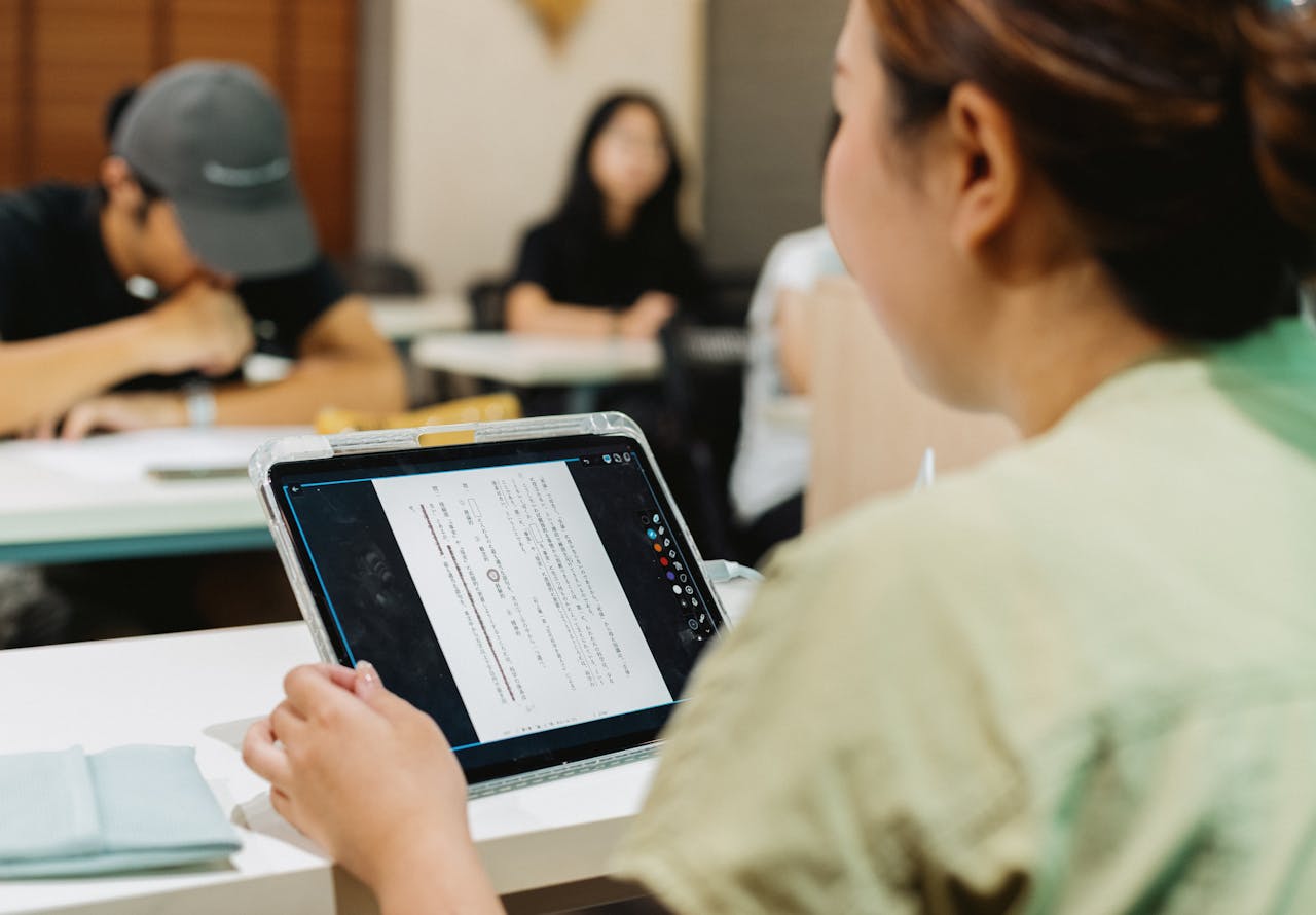 hero-img Students in a Japanese classroom using a tablet for digital learning, fostering modern education.