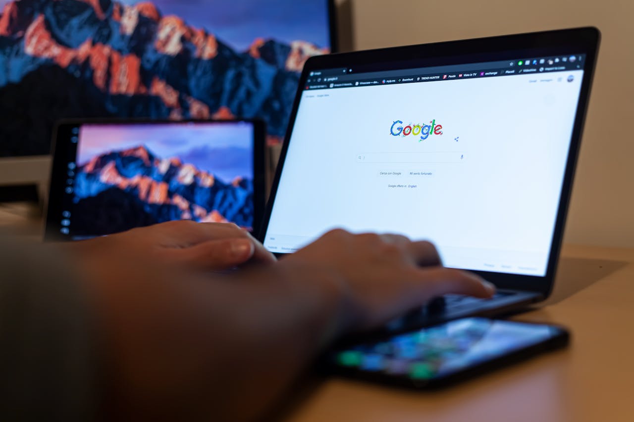 about-01 Hands typing on a laptop with Google on screen, in a remote work setup in Milan, Italy.